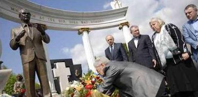 Писатель Дэви Аркадьев кладет цветы на могилу Валерия Лобановского на Байковом кладбище. За ним в окружении Григория и Игоря Суркисов стоит вдова Лобановского Аделаида Панкратьевна, фото gpu-ua.info