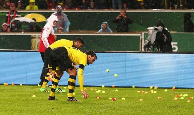 Игроки Боруссии помогают очистить поле от теннисных мячей, Getty Images